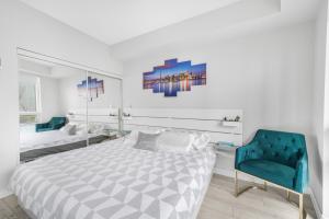 多伦多Luxury Downtown Toronto 2 Bedroom Suite with City and Lake Views and Free Parking的一间卧室配有一张床和一张蓝色椅子