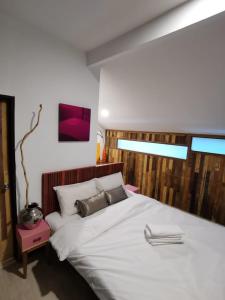 怡保7 Wooden Lodge Ipoh City的卧室配有一张白色大床,墙上配有电视