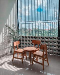 勒吉安Olivia SOHO Guest House的窗前的两把椅子和一张桌子