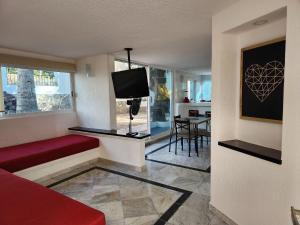 阿卡普尔科Secretos del Sol Acapulco villas a 5 minutosdel mar的客厅配有红色沙发和电视