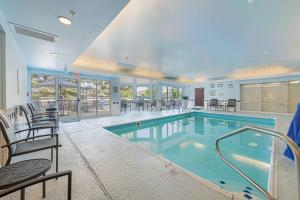 内珀维尔万豪芝加哥内珀维尔费尔菲尔德客栈及套房酒店的大楼内带桌椅的大型游泳池