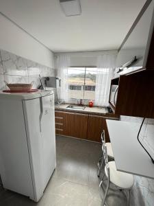 布鲁马迪纽Casa Lua的厨房配有白色冰箱和窗户。