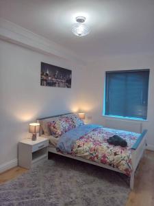 格雷夫森德Heronsgate GH015的一间卧室配有床、床头柜和窗户