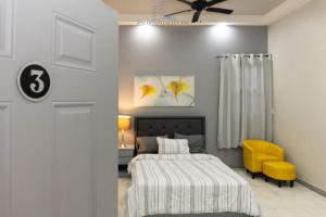 乔治敦592 Apartments 12 Duncan Street Campbellville, Georgetown的一间卧室配有一张床和一张黄色椅子
