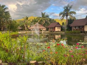 拜县Pairadise Hotel的度假村内一个种满鲜花的池塘和一个喷泉