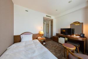 旭川旭川新月酒店的配有一张床和一张书桌的酒店客房
