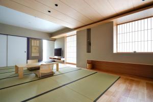 东京Kaminarimon Ryokan的客厅配有桌椅和窗户。