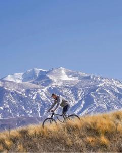 图蓬加托火山Hotel De Cielo的骑着自行车的人在山丘上骑着雪覆盖的山