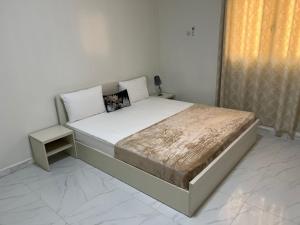 努瓦克肖特1704 Najah Tevragh Zeina的一间卧室配有一张大床和床头柜