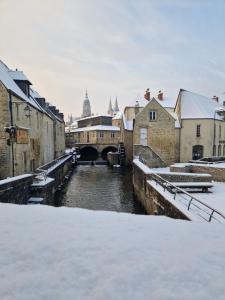 Saint-Vigor-le-GrandLe Chalet de St Vigor的雪覆盖的城市河流