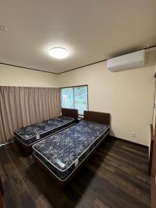下吕市下呂スプリングスロッジ的配有两张床的客房内的两张床垫