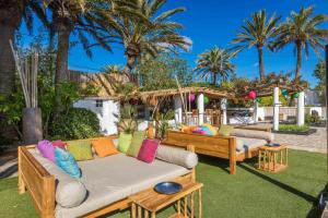 圣埃乌拉利亚伊比扎森酒店的一个带两张沙发和棕榈树的庭院