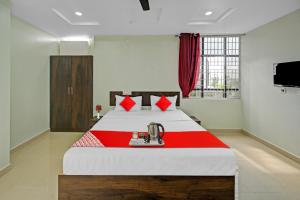 KurmannapalemOYO VRK Residency的一间卧室配有一张带红色毯子的大床