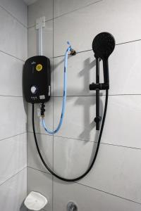 马六甲Amber Cove Melaka Icon stay的浴室内连接淋浴的软管