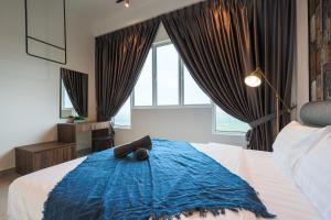 马六甲Amber Cove Melaka Icon stay的一间卧室配有一张带蓝色毯子的大床