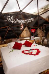 卡拉尔卡Happy Glamping Quindio - Tipo Domo Traslúcido的帐篷里一张有红色鲜花的床