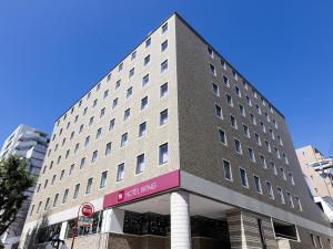 静冈Hotel Wing International Shizuoka的前面有粉红色标志的大建筑