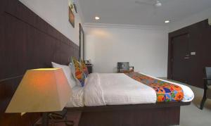 舍地Hotel Shree Sai Wada Shirdi的一间卧室配有一张大床和一盏灯