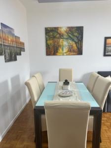 梅拉诺CEJM Apartments Merano的一间配备有蓝桌和白色椅子的用餐室