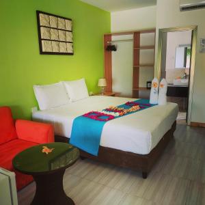 南迪Nadi Fancy Hotel的一间卧室配有两张床和红色椅子