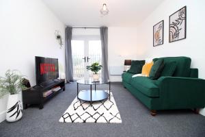 卡迪夫New Modern 1 Bedroom Apartments - Prime Location - By EKLIVING LUXE Short Lets & Serviced Accommodation - Cardiff的客厅配有绿色沙发和电视