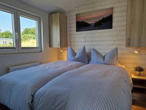 霍尔斯泰因地区诺伊斯塔特Lotse 01的卧室设有一张大白色床和两个窗户