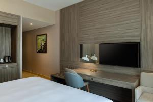 迪拜Four Points by Sheraton Production City, Dubai的酒店客房配有一张床、一张书桌和一台电视。