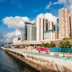 香港宜必思香港北角酒店的水边人行道上摆放着五颜六色椅子的城市