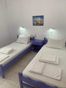 米克罗斯雅洛斯ΜΕΤΑΧΑ的两张睡床彼此相邻,位于一个房间里