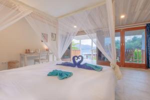 Airtembago塔拉萨雷姆贝潜水度假村的卧室的床上有两条天鹅绒毛巾