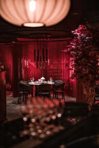哥德堡Clarion Hotel The Pier的一间用餐室,配有红色窗帘和桌椅