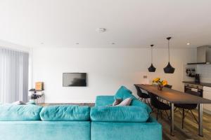 Saint Martin2 bedroom luxury beach apartment Millendreath的客厅配有蓝色的沙发和桌子
