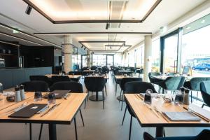 慕尼黑GREFIS Hotel的餐厅设有木桌、椅子和窗户。