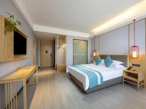 滁州格林东方滁州市政府花园东路酒店的卧室配有一张白色大床和一张书桌