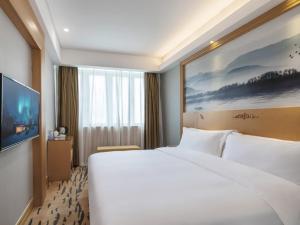 深圳格林东方深圳福田区市民中心景田地铁站酒店的酒店客房设有一张白色大床和电视。