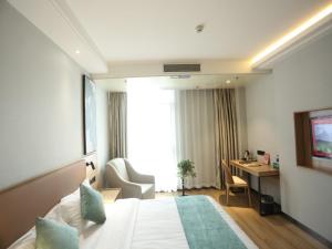 安庆格林豪泰安庆市迎宾东路高铁站客运中心酒店的配有一张床和一张书桌的酒店客房
