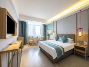 滁州格林东方滁州市政府花园东路酒店的配有一张床和一张书桌的酒店客房