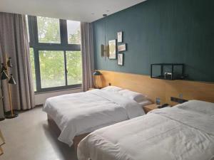 Hejialiang格林豪泰兰州中川机场兰石酒店的酒店客房设有两张床和窗户。