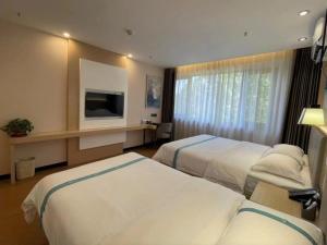 武清格菲天津武清区雍阳西道佛罗伦萨小镇酒店的酒店客房设有两张床和电视。