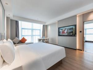 重庆格林东方重庆江北国际机场鹿山地铁站酒店的一间白色的大卧室,配有一张大床和一台电视