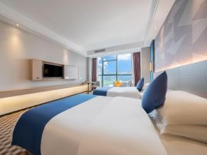玉林格林豪泰玉林宏进市场毅德酒店的酒店客房设有两张床和电视。