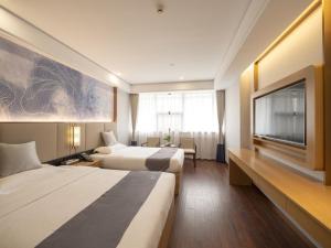 无锡格林东方蠡湖鼋头渚风景区酒店的酒店客房设有两张床和一台平面电视。