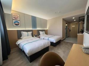 砀山格菲安徽省宿州砀山县中原路酒店的酒店客房配有两张床和一张书桌