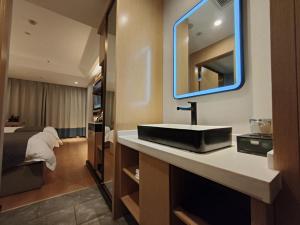 乌鲁木齐格林东方新疆乌鲁木齐人民路酒店的一间带水槽、床和镜子的浴室