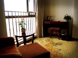 安庆格林豪泰安庆市迎宾东路高铁站客运中心酒店的客厅配有沙发、桌子和书桌