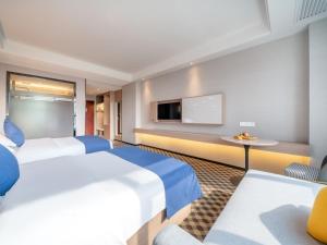 玉林格林豪泰玉林宏进市场毅德酒店的一间酒店客房,设有两张床和电视