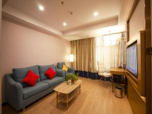 浚县格林东方鹤壁市浚县客运站酒店的客厅配有蓝色沙发和红色枕头