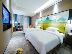 重庆格林东方重庆解放碑儿童医院酒店的一间酒店客房,设有三张床和一台平面电视