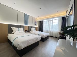 砀山格菲安徽省宿州砀山县中原路酒店的酒店客房设有两张床和大窗户。