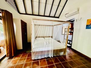 阿鲁甘湾Riva del Sole Guest House的一间卧室配有一张带蚊帐的床